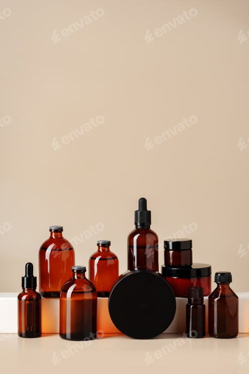 Preview: Set of brown glass bottles with essential oils on stand on beige background
