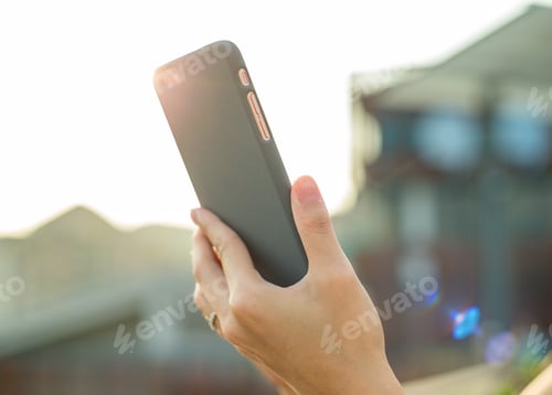 Preview: Woman using cellphone under sunlight