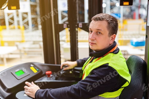 Preview: Storehouse employee in uniform working on forklift in modern automatic warehouse. Boxes are on the
