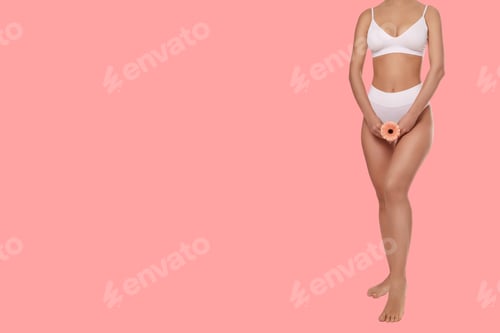 Preview: Woman demonstrates body care with flower on pink backdrop