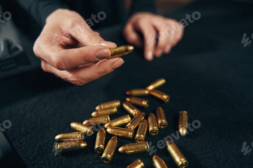 Preview: Woman sitting at a table with ammunition