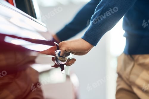 Preview: Hand of male businessman opening car door