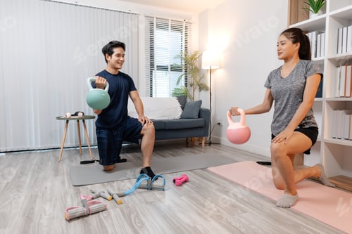 Preview: A young couple exercising together at home, smiling and enjoying their workout routine.
