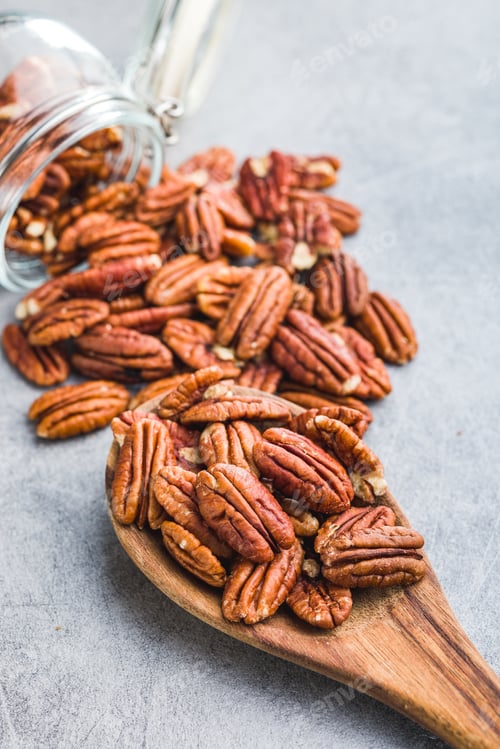 Preview: Peeled pecan nuts in wooden spoon.