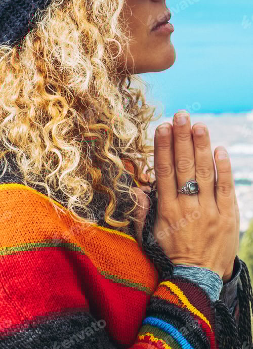 Preview: Close-up of calm young Caucasian woman holding hands on heart chest and feeling grateful