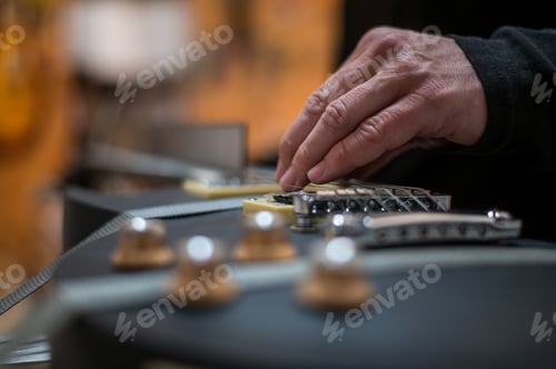 Preview: Black electrical guitar in a service repair workshop