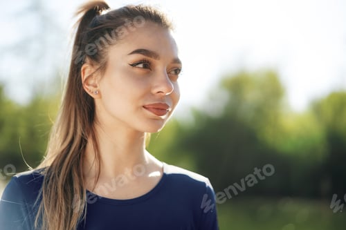 Preview: Portrait of a young smiling woman wearing sportswear in morning park