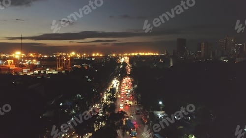 Preview: Night traffic road closeup aerial. Cars, trucks drives at modern buildings, skyscrapers at twilight