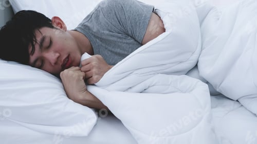 Preview: Asian man feeling cold while sleeping at home.