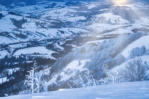 Preview: Fluffy clouds shelter under white snow sheltered by forests and beautiful mountains