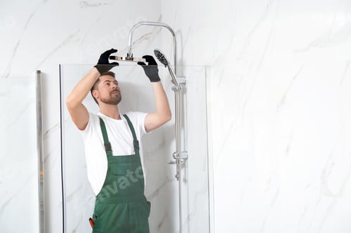 Preview: Professional handyman working in shower booth indoors, space for text