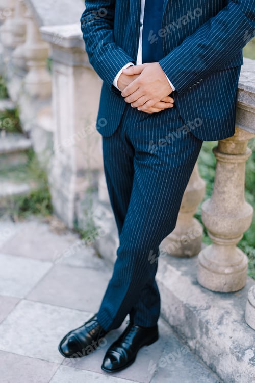 Preview: Man in a suit stands near the steps, leaning on a handrail
