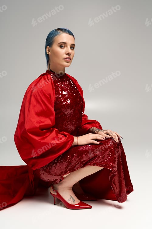 Preview: Festive winter elegance with a beautiful young woman in a shimmering red ensemble