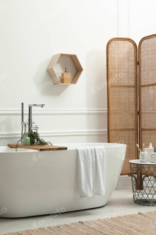 Preview: Modern ceramic bathtub and green plant near white wall in room