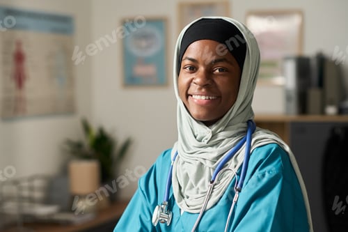 Preview: Smiling Muslim Female Doctor Wearing Medical Attire in Clinic