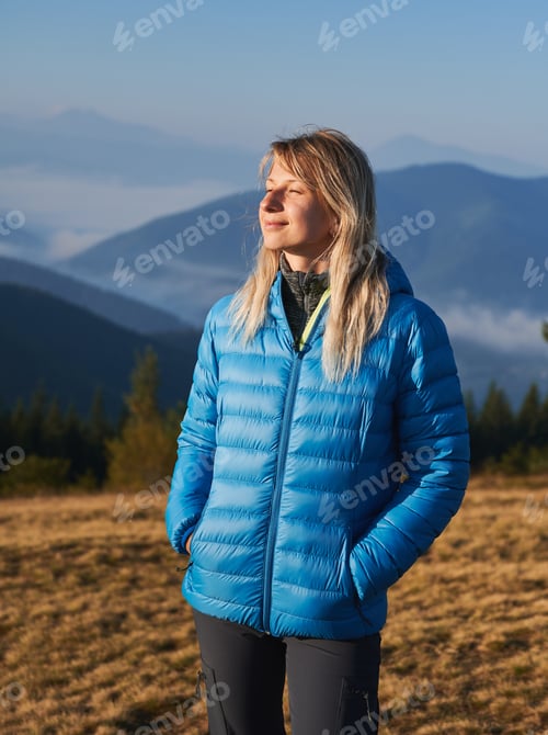 Preview: Alone blonde girl walking in the mountains.