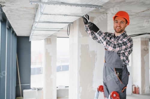 Construction worker installing ventilation system in building