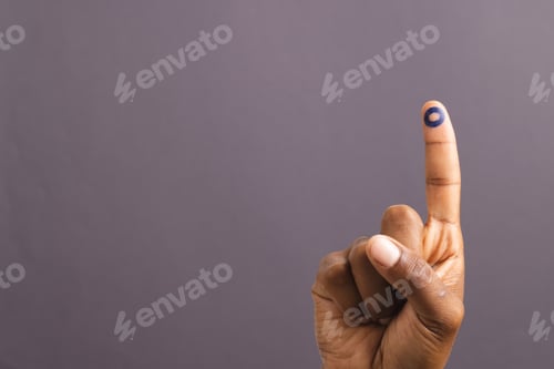 Preview: Hand of biracial man with blue ring on outstretched finger, on grey background with copy space