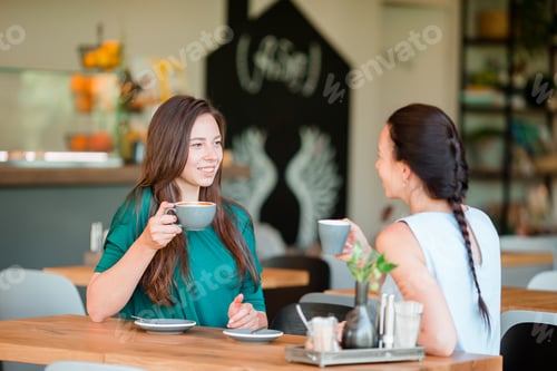 Preview: Happy smiling young women with coffee cups at cafe. Communication and friendship concept