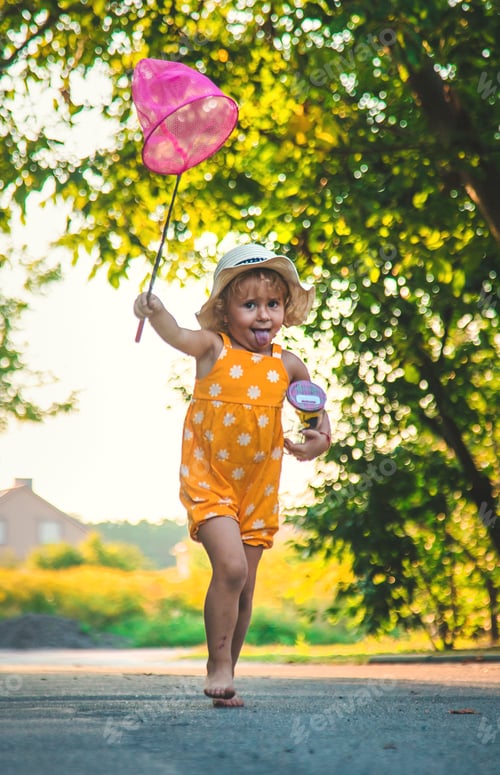 Preview: A child catches a butterfly in nature. selective focus.
