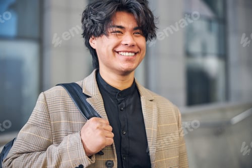 Preview: Attractive young man looking away and smiling