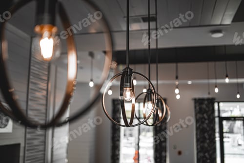 Preview: Selective focus shot of a modern lamp with a light bulb inside the building