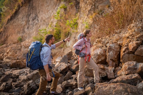 Preview: Tourists show helping young woman with backpacks hike on rocky top mountain trekking and soft foggy