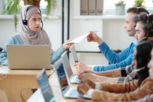 Preview: Young woman giving script to colleague