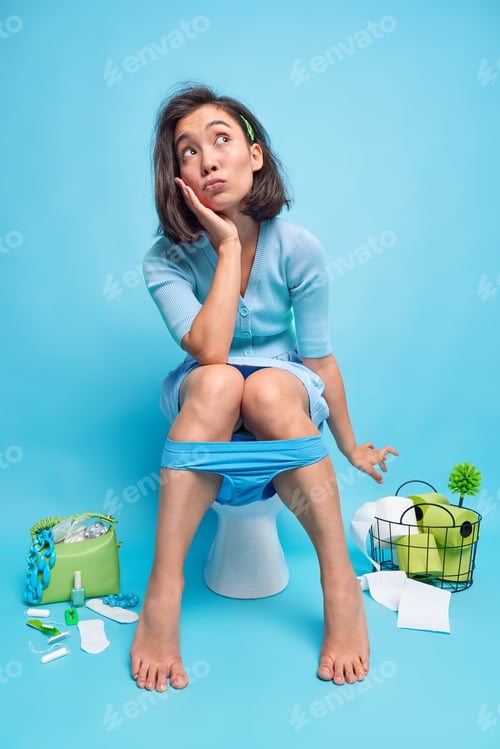 Preview: Full length shot of beutiful relaxed young Asian woman ponders on something while peeing on toilet b