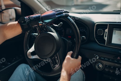 Preview: Young disabled man driver with artificial prosthetic hand driving vehicle car.