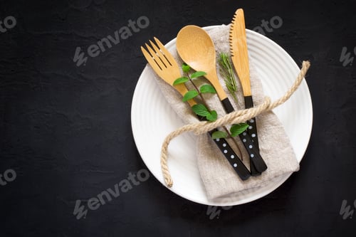 Preview: Elegant Wooden Utensils on White Plate, Dark Background
