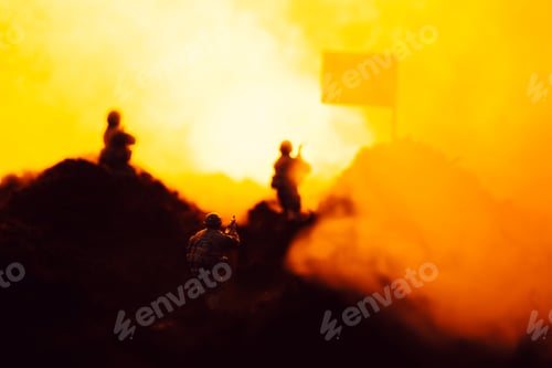 Preview: Selective focus of toy warriors on battleground with smoke, flag and fire at background