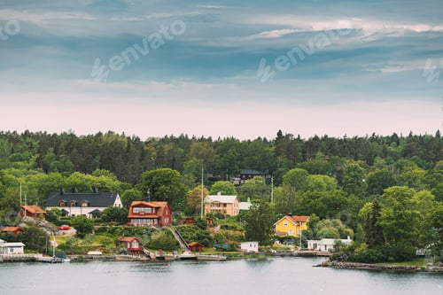 Preview: Sweden. Beautiful Red Swedish Wooden Log Cabin House On Rocky Island Coast In Summer Sunny Evening