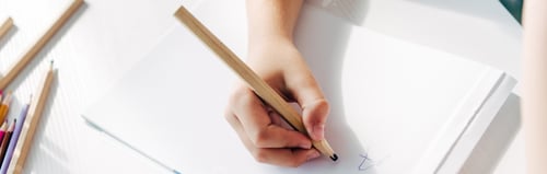 Preview: cropped view of kid with dyslexia drawing on paper with pencil