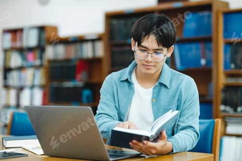 Preview: Young university student using laptop for online learning, searching and learning at library.