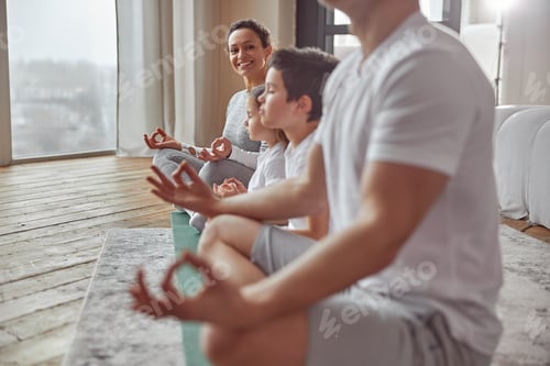 Preview: Happy woman enjoying meditation with family at home