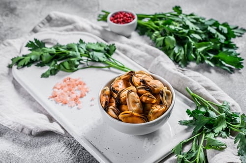 Preview: Boiled mussel meat on a cutting Board. Healthy seafood. Light background.