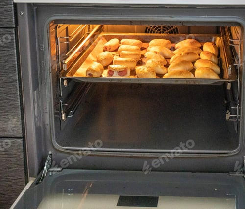 Preview: The concept of cooking homemade food, freshly baked hot pies with filling on a baking sheet