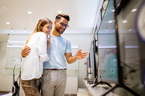 Preview: Young couple in consumer electronics store looking at latest digital devices, television.