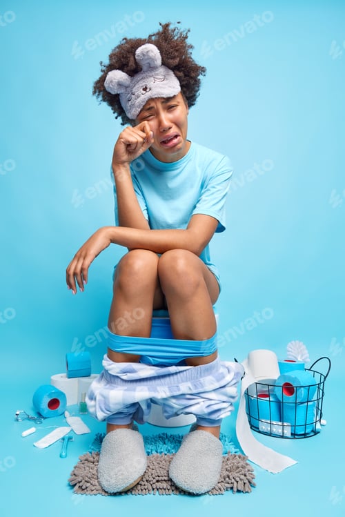 Preview: Depressed Afro American woman has problems with healthy suffers from diarrhea or hemorrhoids poses o