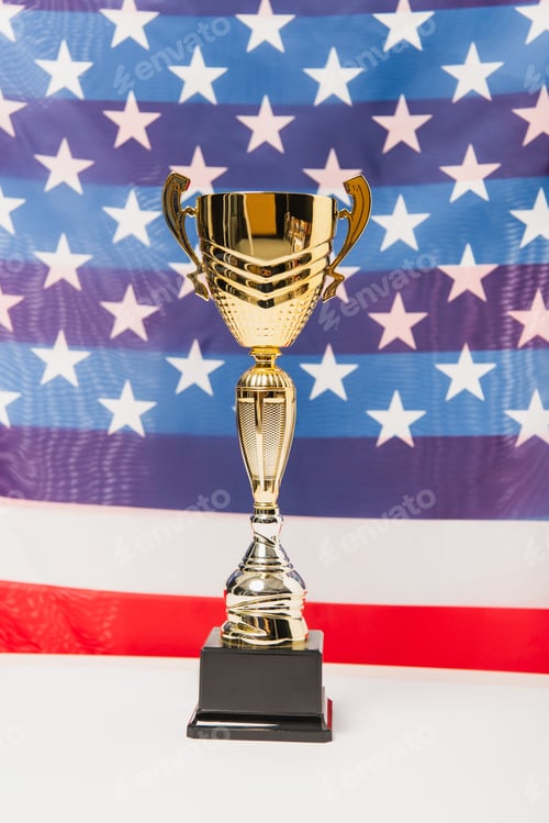 Preview: golden cup with stars and stripes of american flag on blurred background