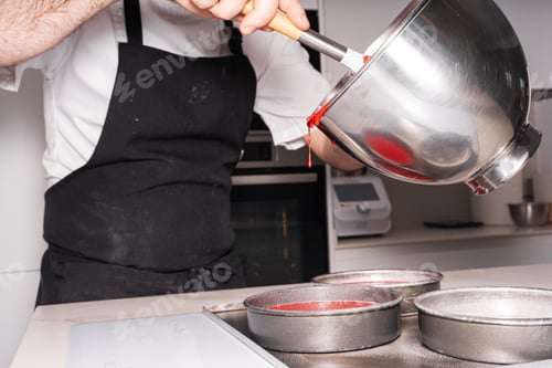 Preview: man cooking a red velvet cake at home, adding the sponge cake in the molds before putting