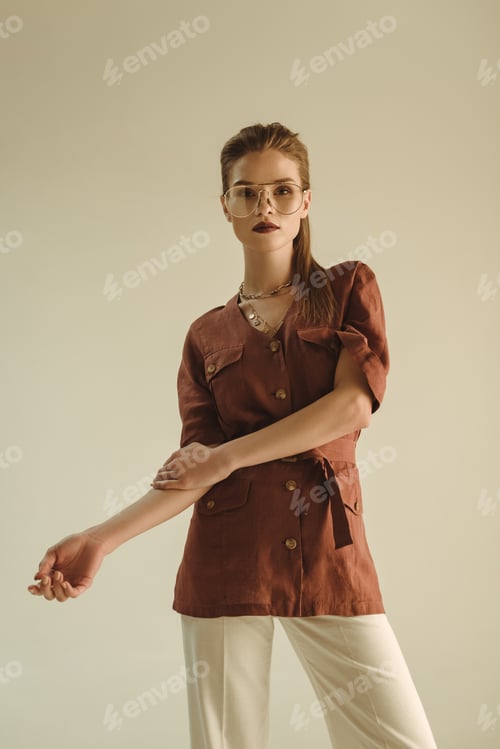 Preview: fashionable young woman posing in trendy vintage clothing isolated on beige