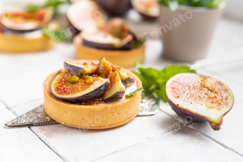 Preview: Tasty tartlets with cream cheese and figs on grey tilled background
