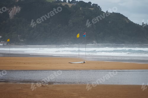 Preview: Flags and a surfboard on beach