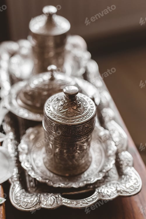 Preview: Vertical closeup shot of an antique silver tea set with a blurry background