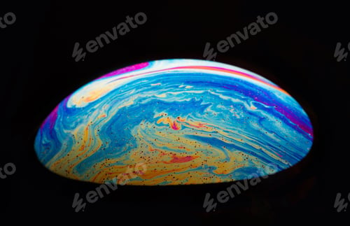 Preview: Close-up shot of a rainbow soap bubble in a dark background.