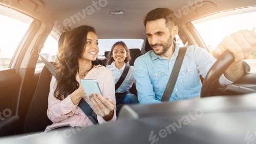 Preview: Family enjoying a car ride with mother holding a phone and child smiling in the back