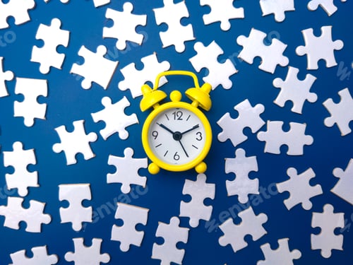 Preview: Yellow alarm clock and white puzzle on a blue background