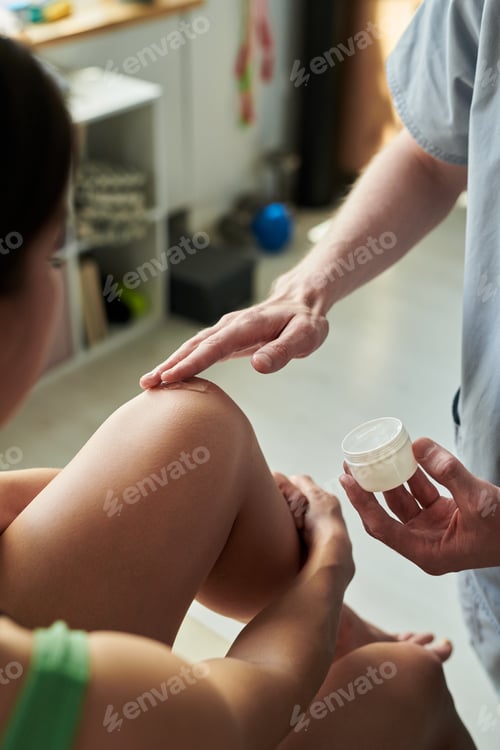 Preview: Applying Cream on Patient's Knee in Medical Setting